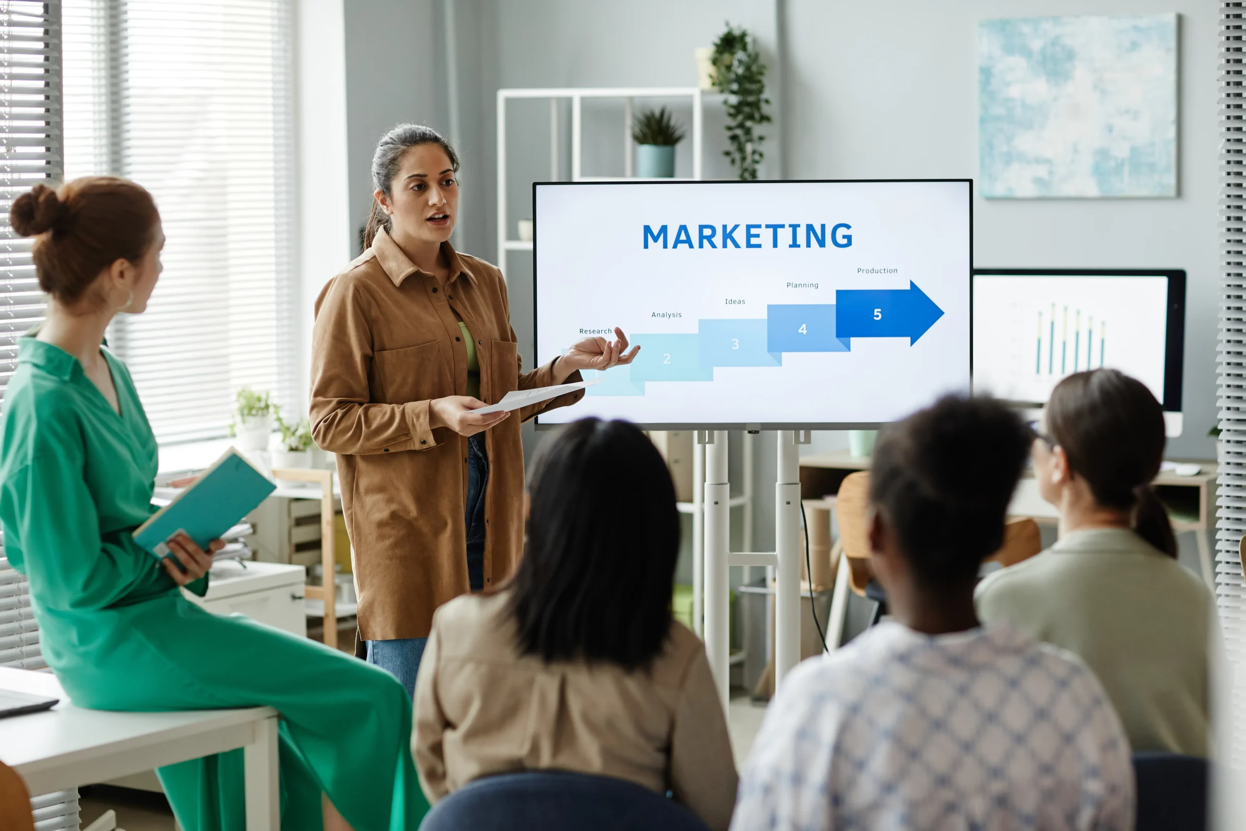 woman-presenting-marketing-strategy-to-colleagues-2026-01-08-07-14-43-utc
